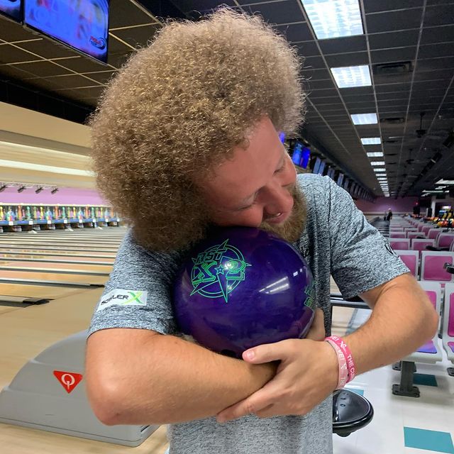 Kyle Troup hugging his bowling ball with great love.